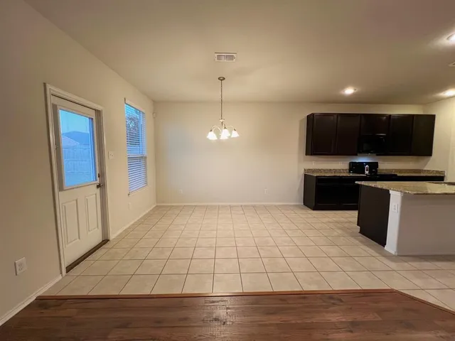 a view of an empty room with a fireplace and a window