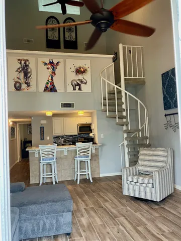 a living room with stainless steel appliances furniture and a kitchen view