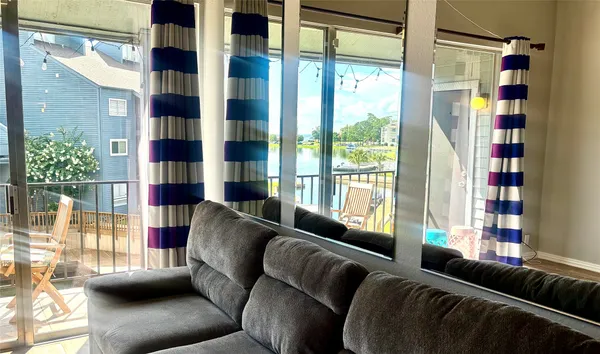 a living room with furniture and a floor to ceiling window