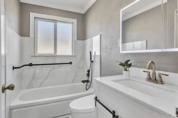 a bathroom with a granite countertop sink toilet and shower