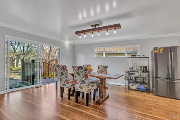 a view of a dining room with furniture large windows and wooden floor
