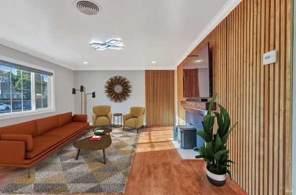 a living room with furniture floor to ceiling window and potted plant