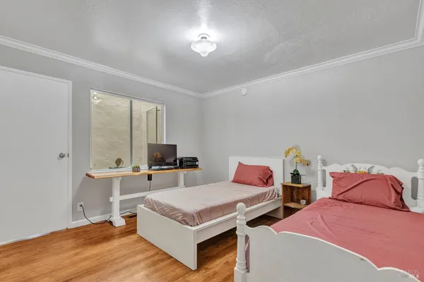 a bedroom with two beds and a potted plant
