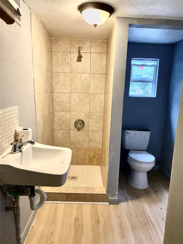 a bathroom with a sink a toilet and shower