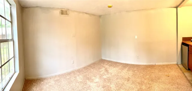 a view of a small space with wooden floor and a window