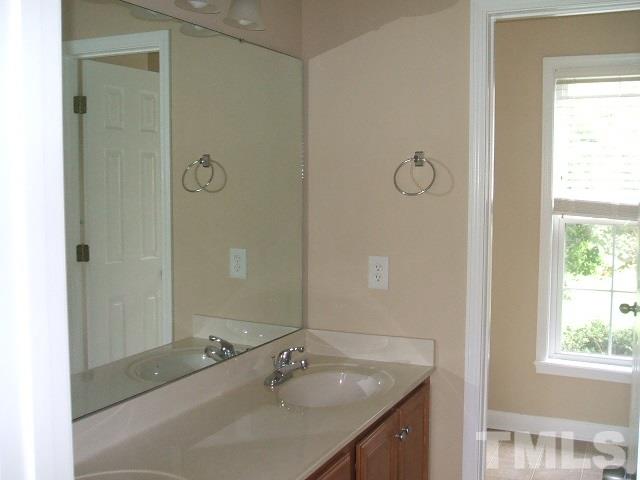 1094 Willie Gray Road Timberlake, NC 27583 - Photo 11 of 15 a bathroom with a granite countertop sink a mirror and a bathtub