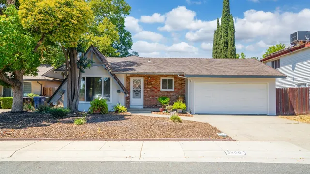 a front view of a house with a garden and outdoor seating