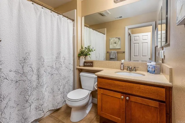 a bathroom with a granite countertop sink toilet and mirror