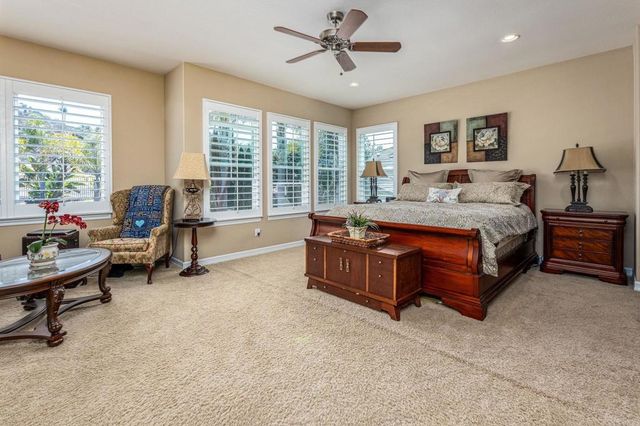 a spacious bedroom with a bed and a chandelier