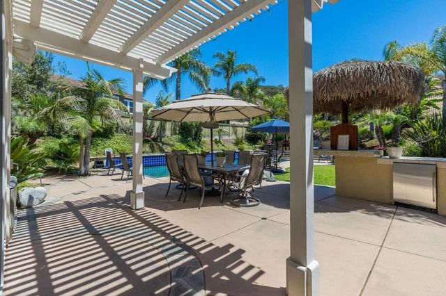 a view of a patio with a table and chairs under an umbrella