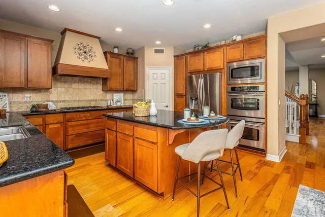a kitchen with stainless steel appliances granite countertop a sink and cabinets