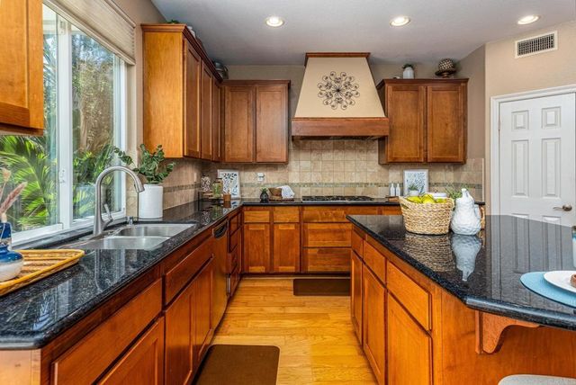 a kitchen with stainless steel appliances granite countertop sink stove and cabinets
