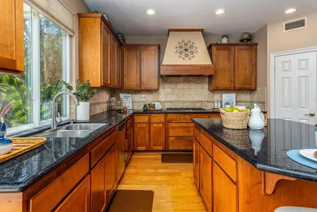 a kitchen with stainless steel appliances granite countertop sink stove and cabinets