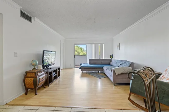 a living room with a bed furniture and a flat screen tv