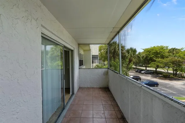 a view of a patio with table and chairs and floor to ceiling window with wooden floor
