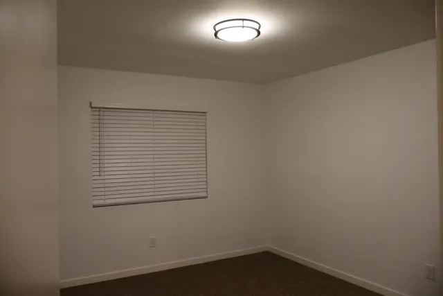 an empty room with closet and a ceiling fan