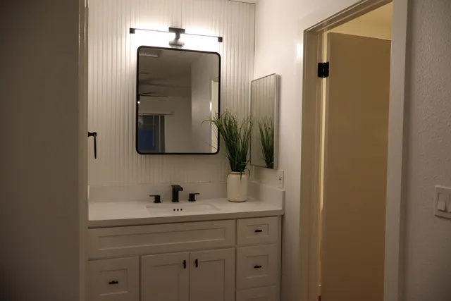 a bathroom with a sink a light fixture and a mirror