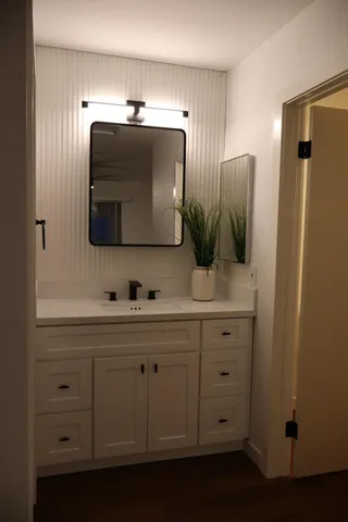 an empty room with wooden floor a ceiling fan and a window