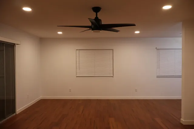 a view of a kitchen with wooden floor a ceiling fan and refrigerator