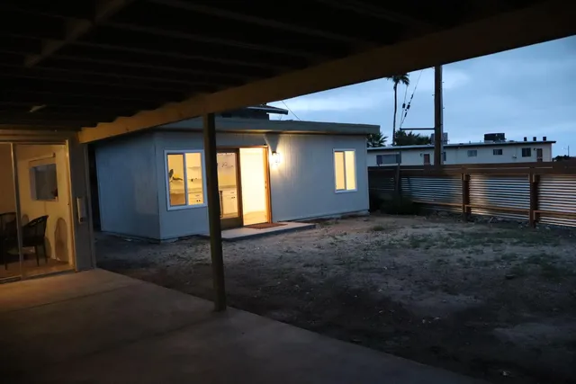 a view of a hallway with wooden floor and chandelier