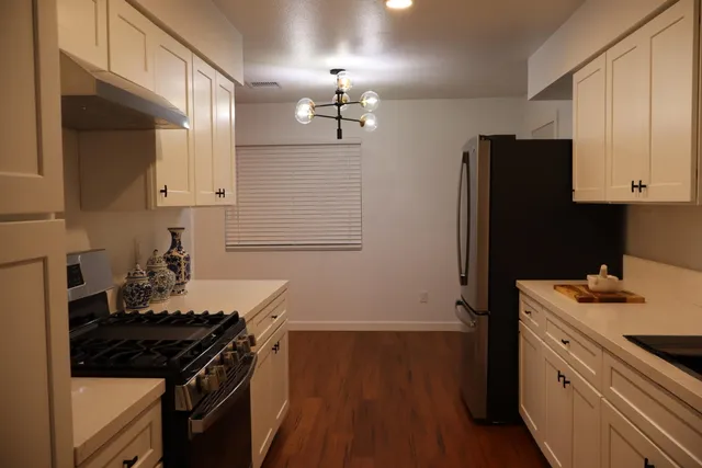 a kitchen with granite countertop a stove and a refrigerator