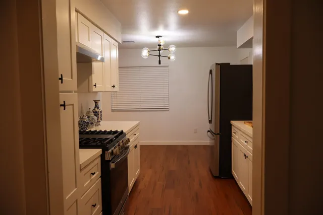 a kitchen with a refrigerator and a stove top oven