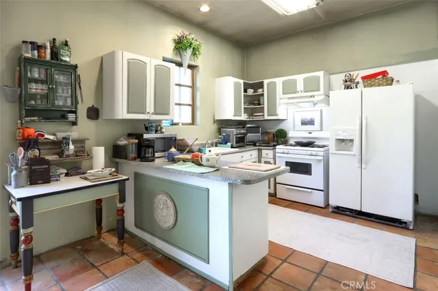 a kitchen with stainless steel appliances white cabinets and white appliances