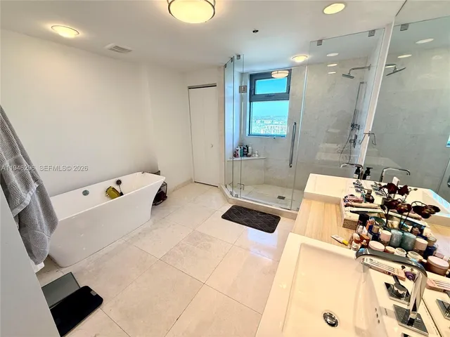 a bathroom with a tub sink and mirror