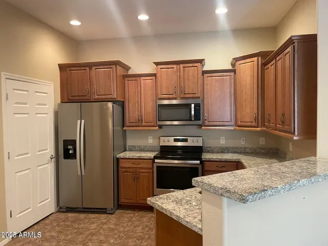a kitchen with stainless steel appliances granite countertop a refrigerator stove and sink