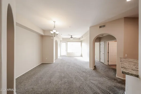 an empty room with chandelier and windows