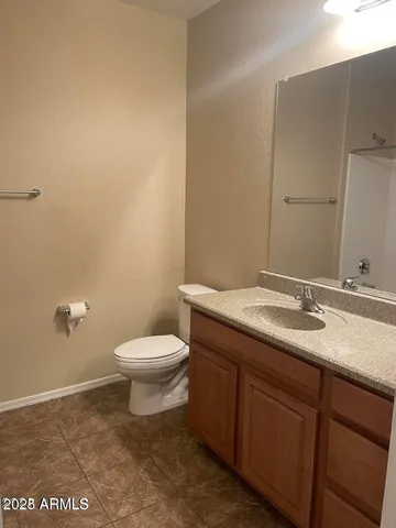 a bathroom with a granite countertop toilet and a sink
