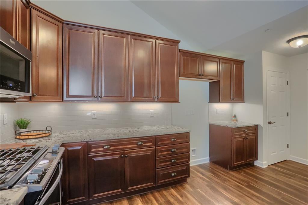 705 Spring Valley Drive Zelienople, PA 16063 - Photo 23 of 34 a kitchen with wooden cabinets and a stove top oven