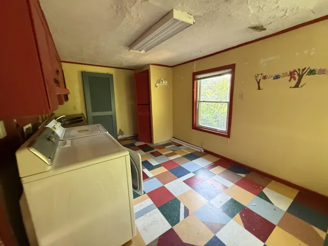 a room with a black white checkered floor with a gaming machine and wooden floor