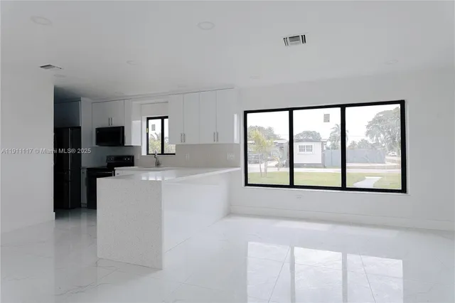 a large white kitchen with a large window