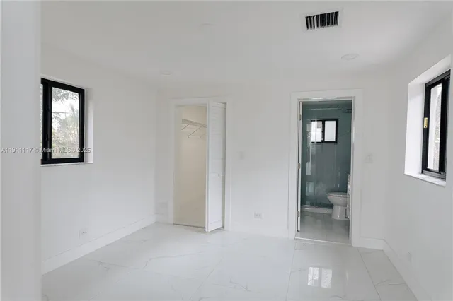 an empty room with windows and closet