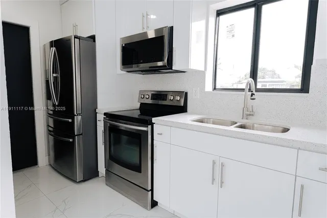 a kitchen with stainless steel appliances a stove microwave and refrigerator