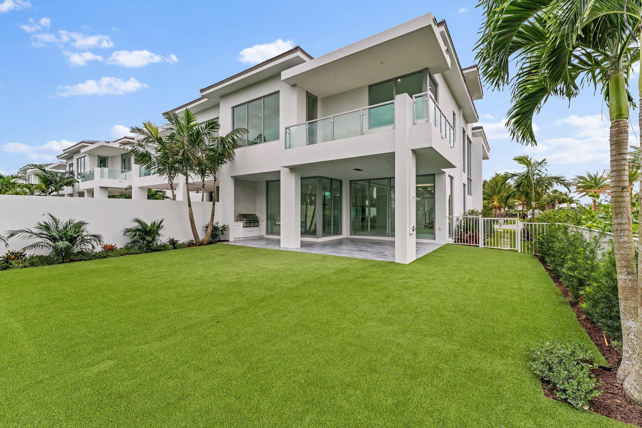423 Ocean One Lane Juno Beach, FL 33408 - Photo 1 of 58 a view of a white house with a big yard and potted plants