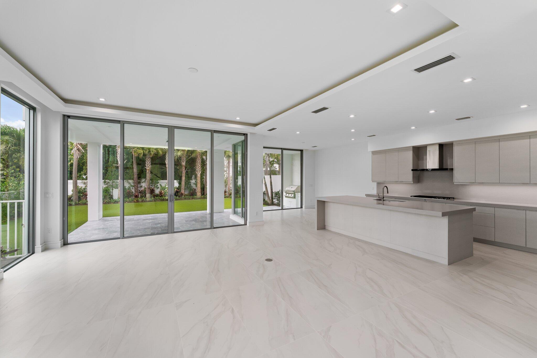 423 Ocean One Lane Juno Beach, FL 33408 - Photo 15 of 58 a view of an empty room with kitchen view and a large window