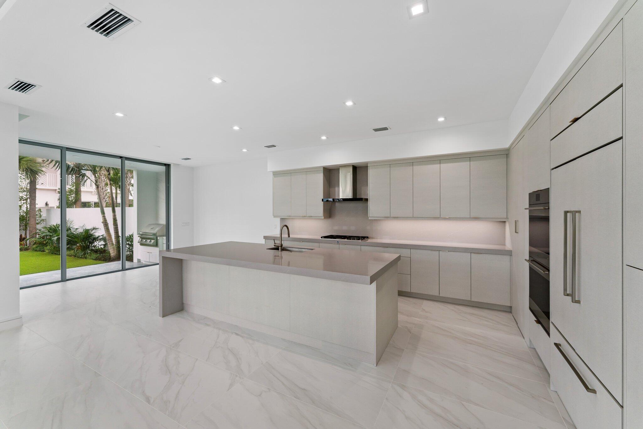 423 Ocean One Lane Juno Beach, FL 33408 - Photo 16 of 58 a large kitchen with kitchen island a sink stainless steel appliances and cabinets