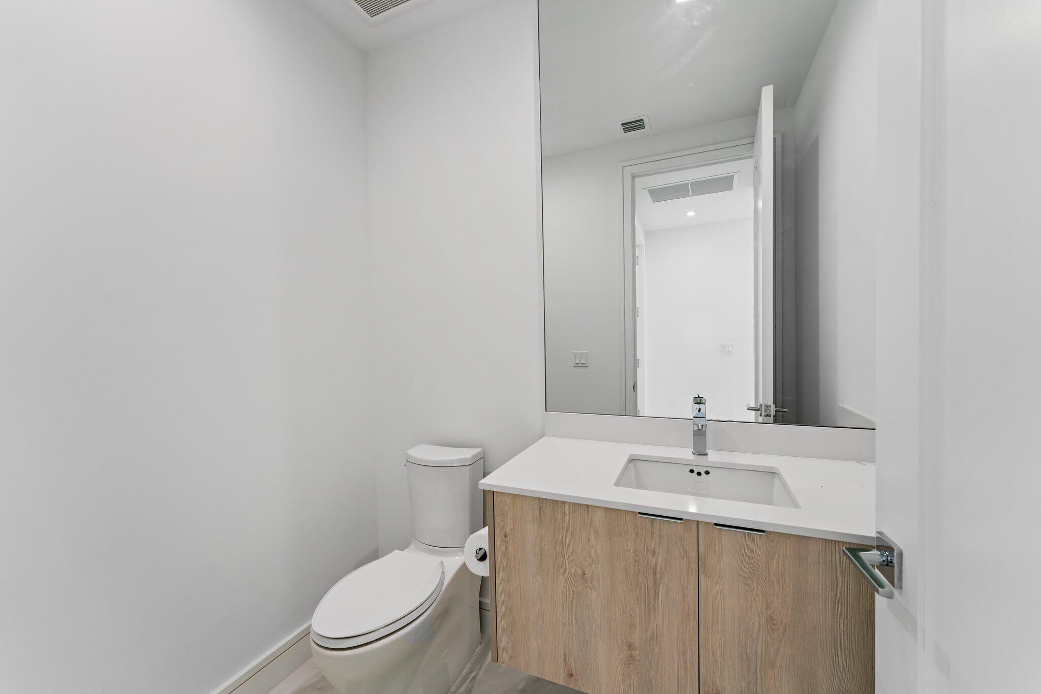 423 Ocean One Lane Juno Beach, FL 33408 - Photo 22 of 58 a bathroom with a toilet a sink a mirror and vanity