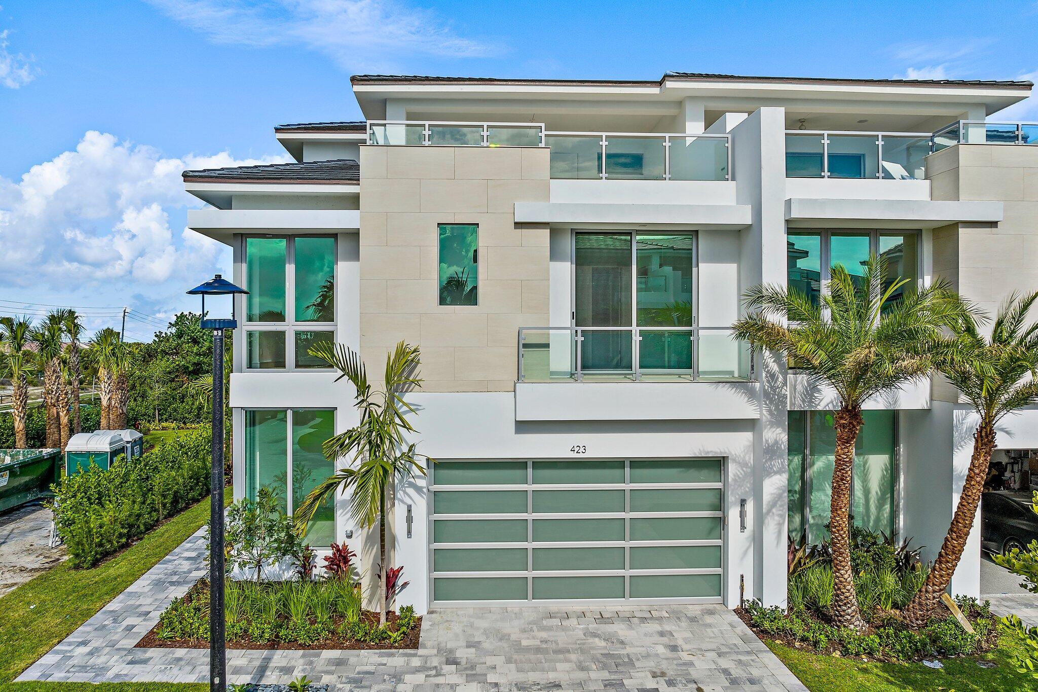 423 Ocean One Lane Juno Beach, FL 33408 - Photo 3 of 58 a front view of a house with a yard