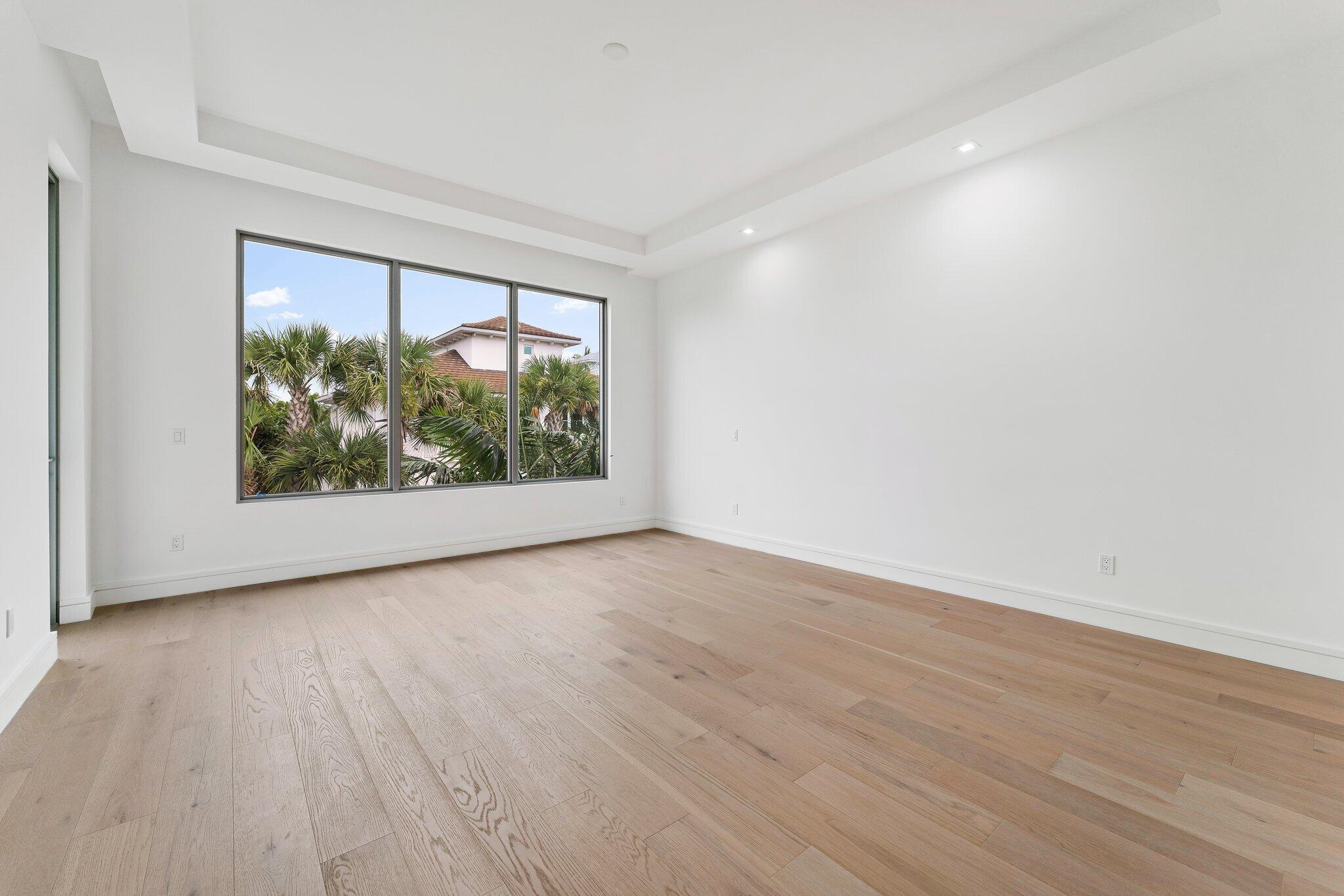 423 Ocean One Lane Juno Beach, FL 33408 - Photo 31 of 58 a view of an empty room with wooden floor and a window