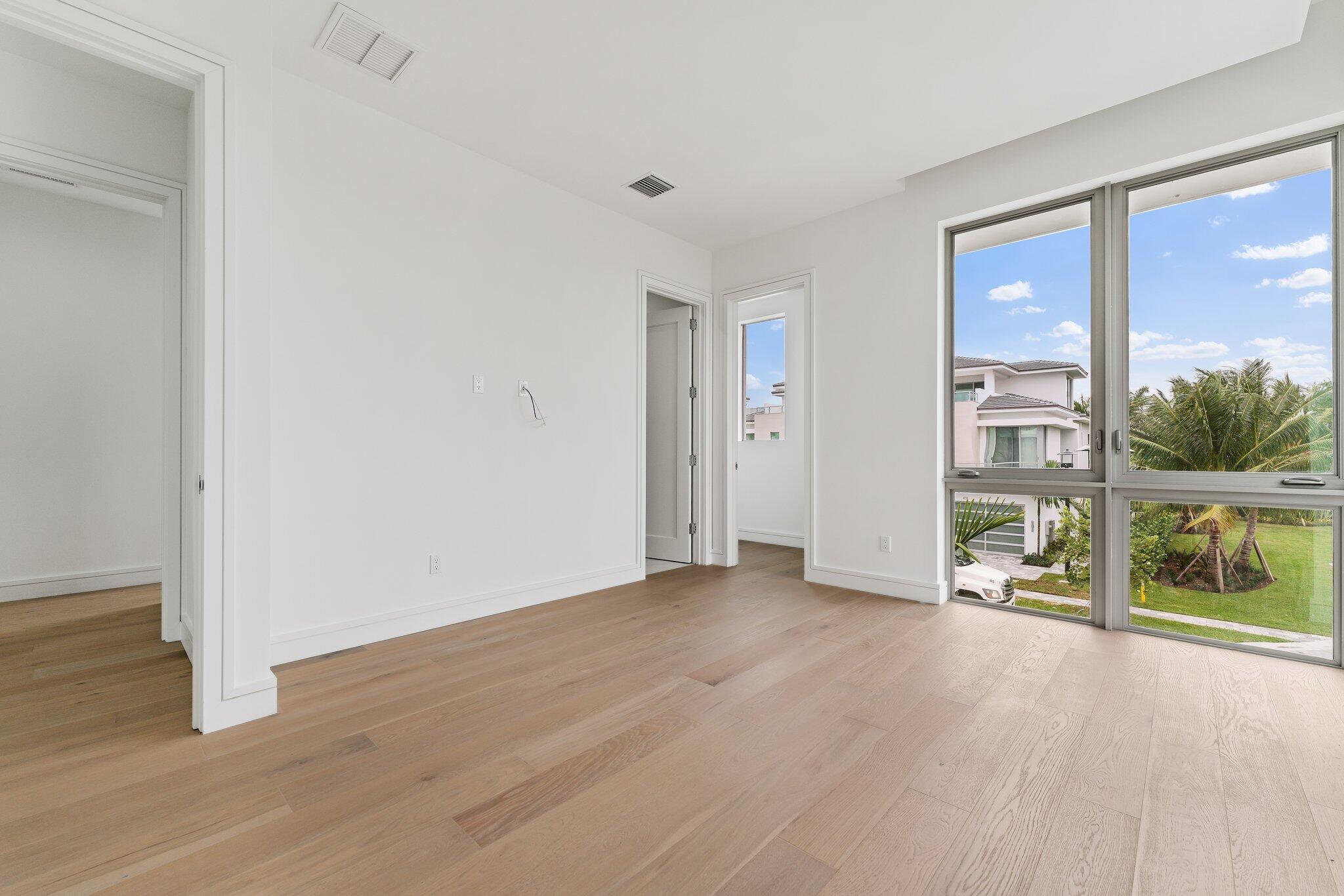 423 Ocean One Lane Juno Beach, FL 33408 - Photo 41 of 58 a view of an empty room with a window and wooden floor