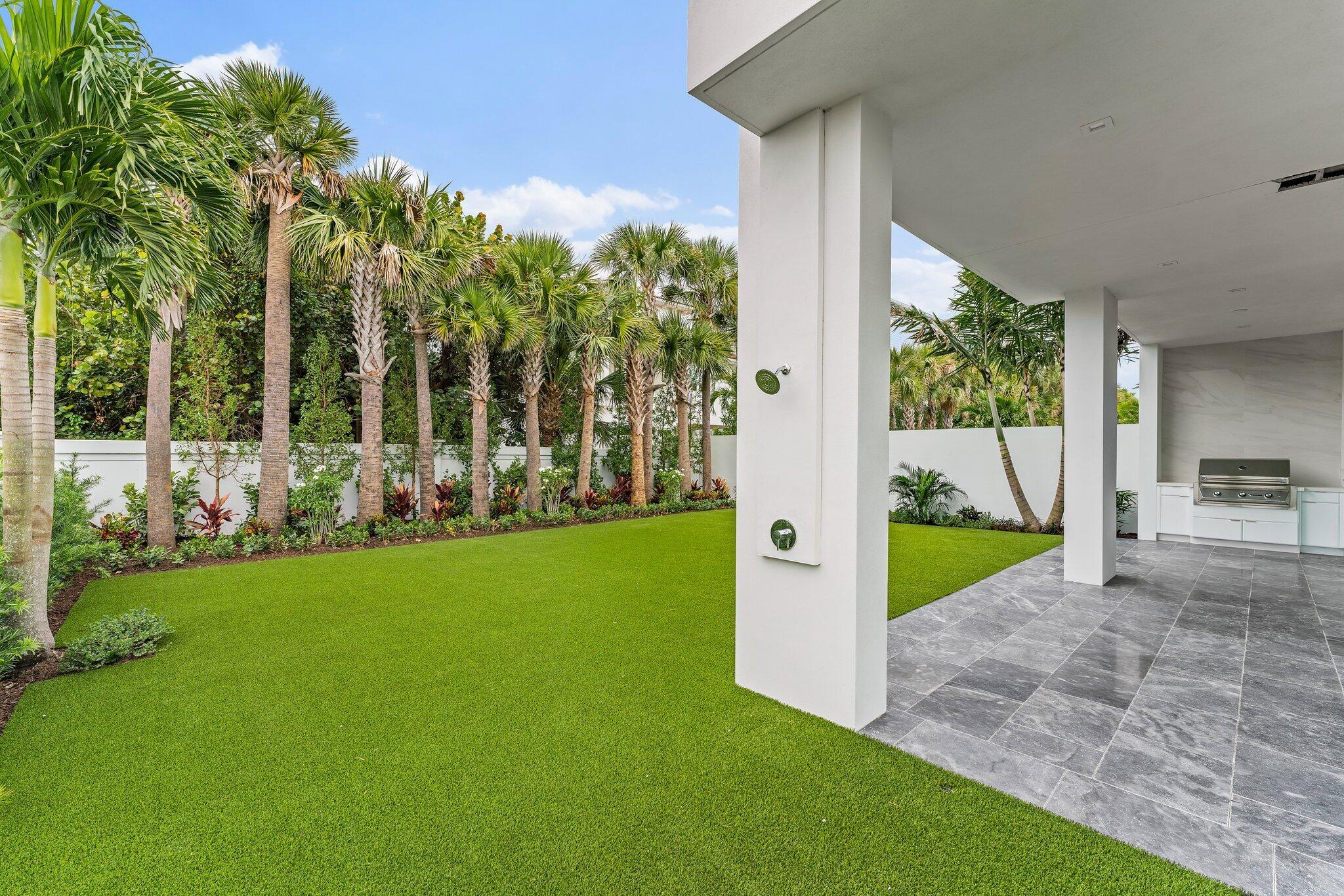 423 Ocean One Lane Juno Beach, FL 33408 - Photo 10 of 58 a view of a backyard with couches plants and palm trees