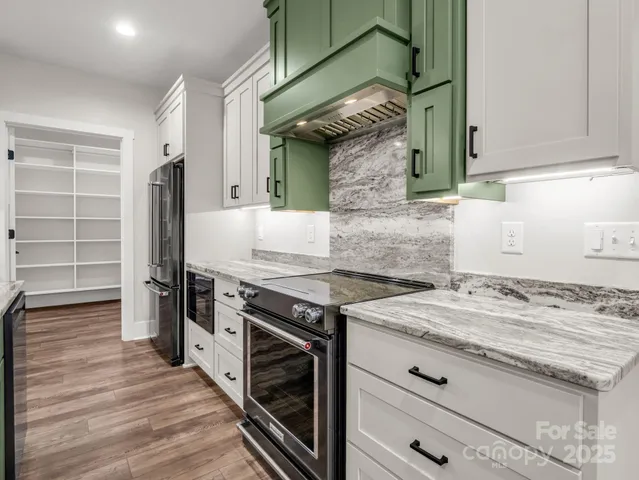 a kitchen with granite countertop a stove and a wooden floors
