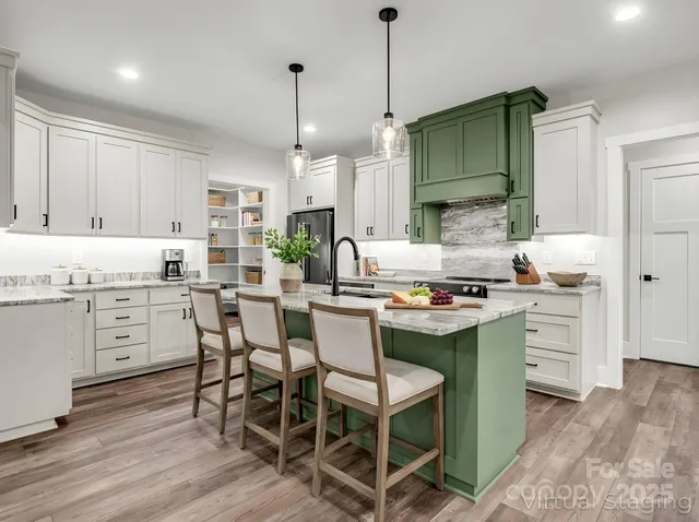 a kitchen with stainless steel appliances kitchen island granite countertop a table chairs and a wooden cabinets