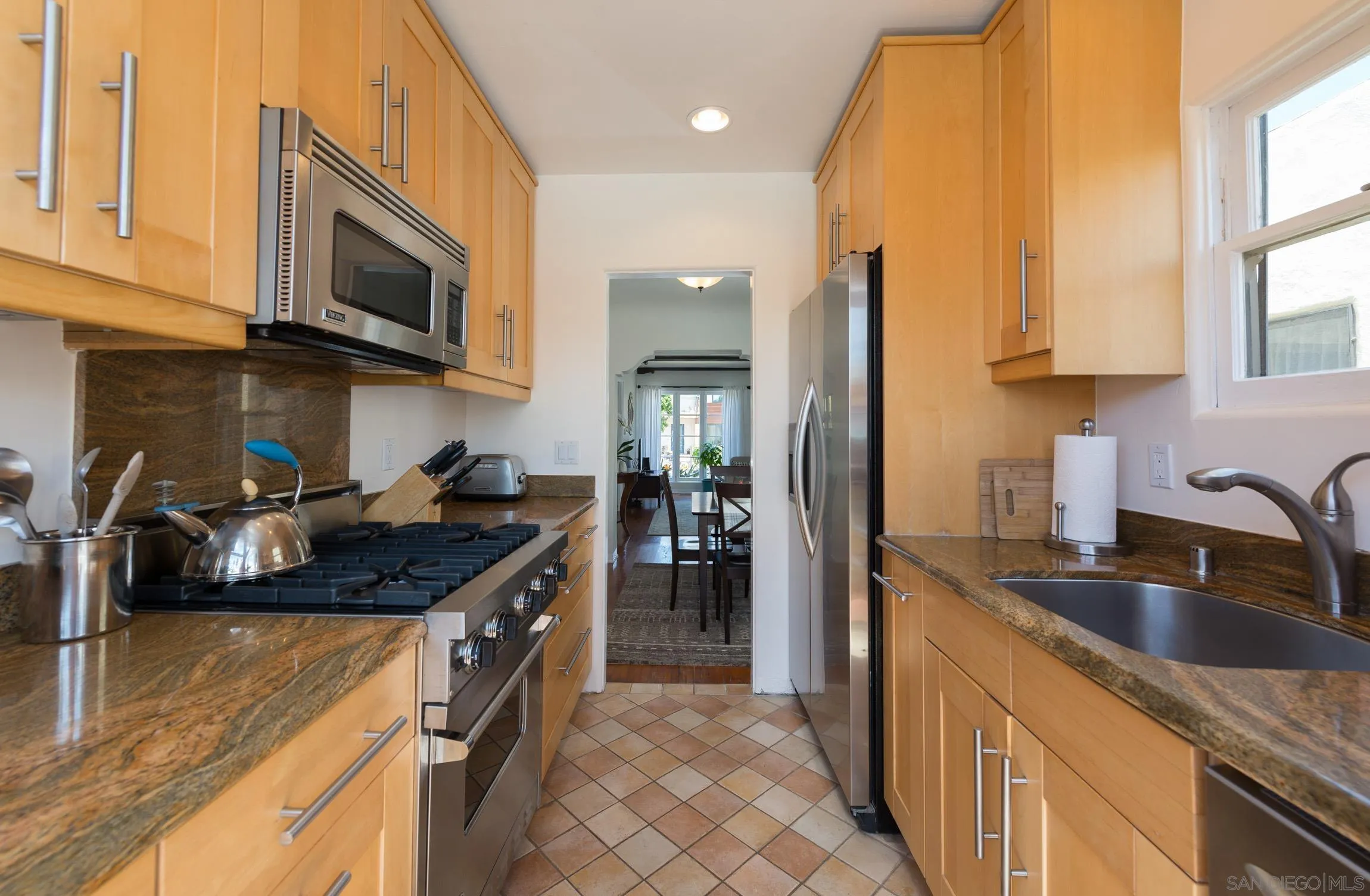 605 Arenas Street La Jolla, CA 92037 - Photo 11 of 25 a kitchen with stainless steel appliances granite countertop a sink stove and refrigerator