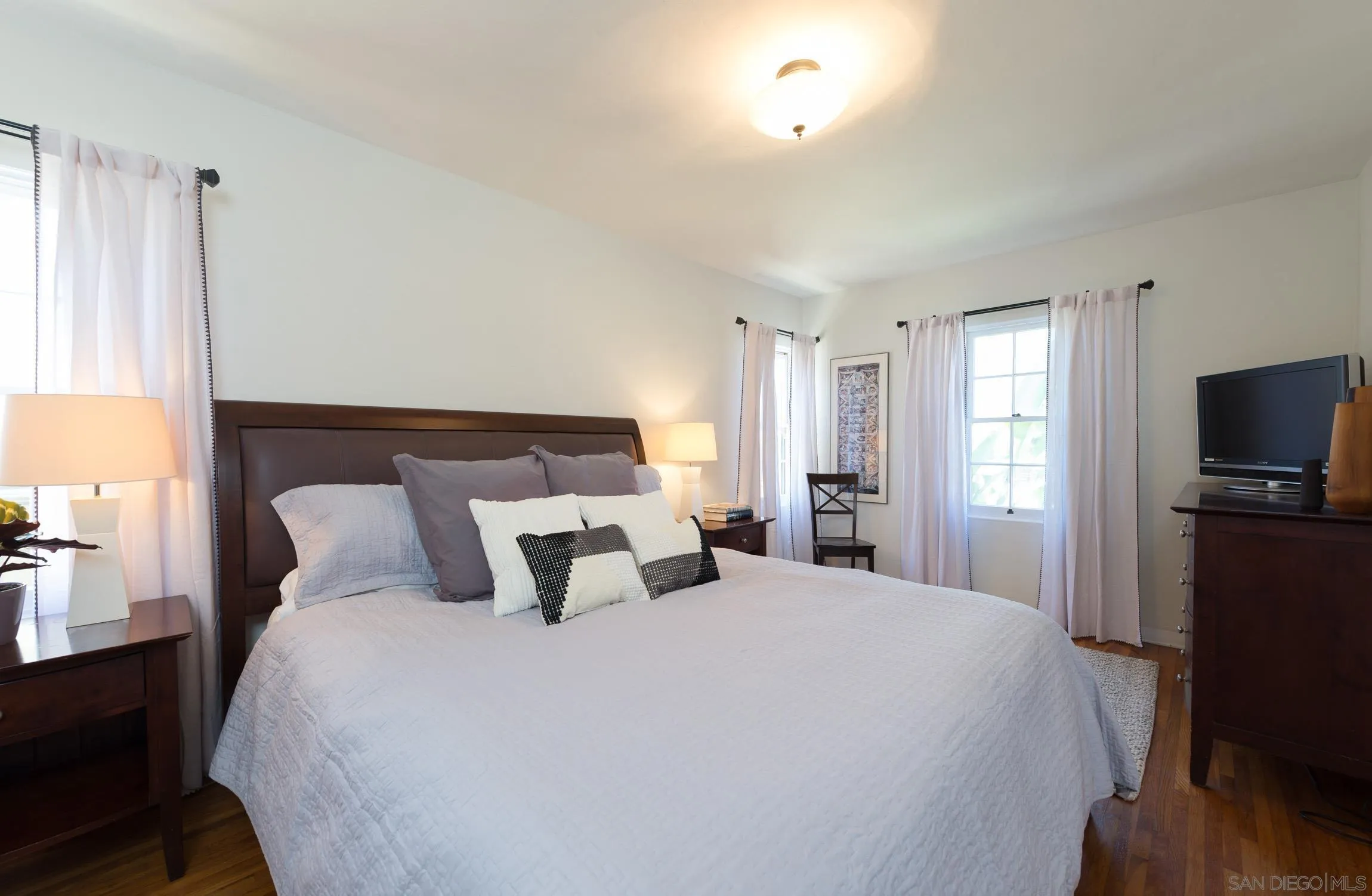 605 Arenas Street La Jolla, CA 92037 - Photo 16 of 25 a bedroom with a large bed and a tv