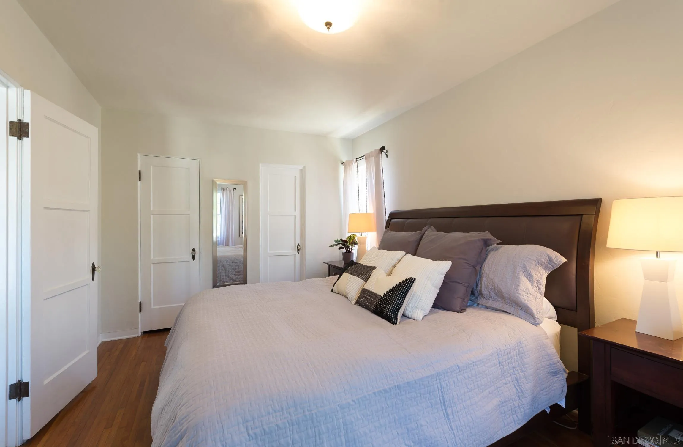 605 Arenas Street La Jolla, CA 92037 - Photo 17 of 25 a bedroom with a bed and wooden floor