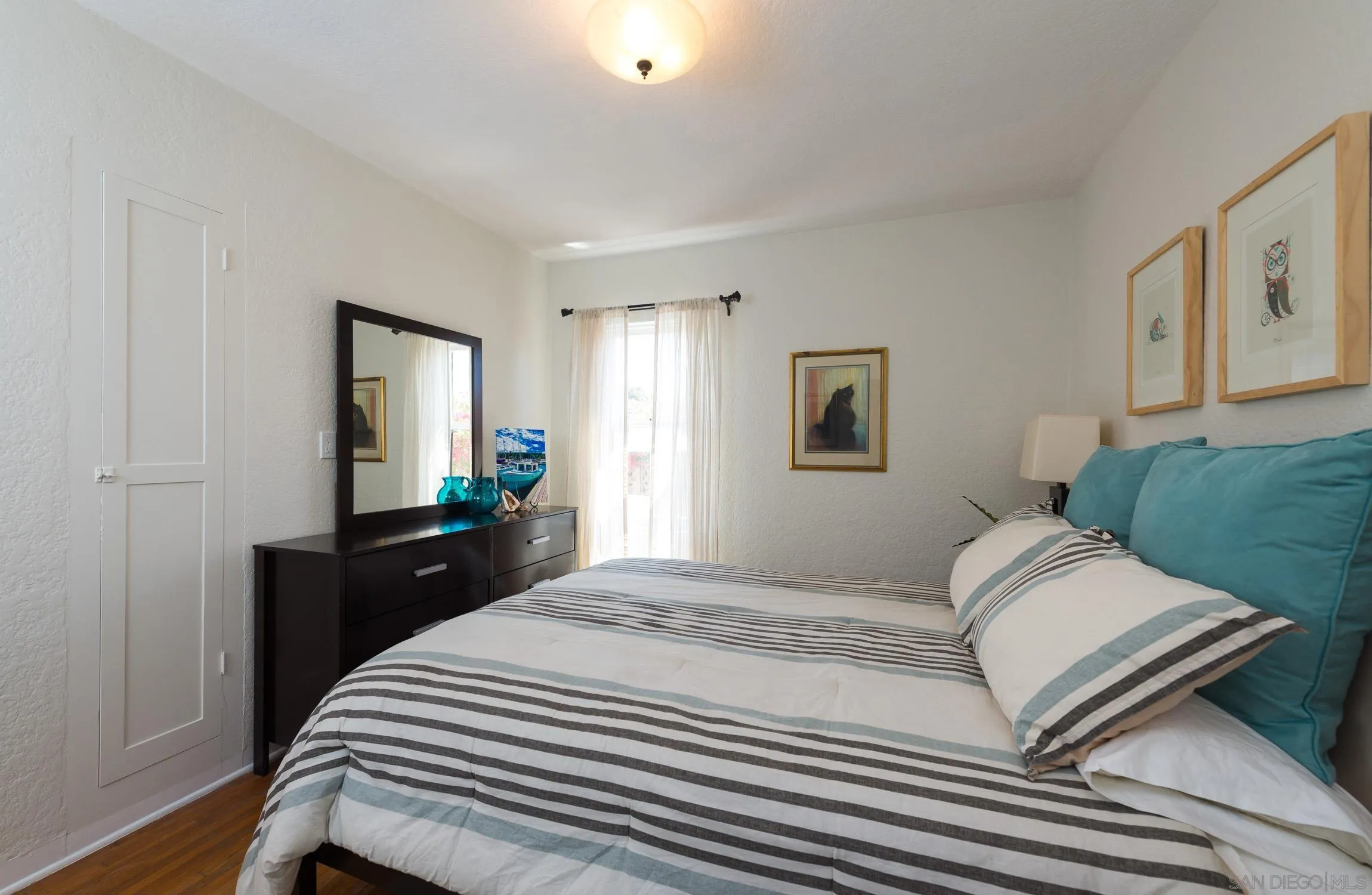 605 Arenas Street La Jolla, CA 92037 - Photo 20 of 25 a bedroom with a bed and a flat tv screen on dresser